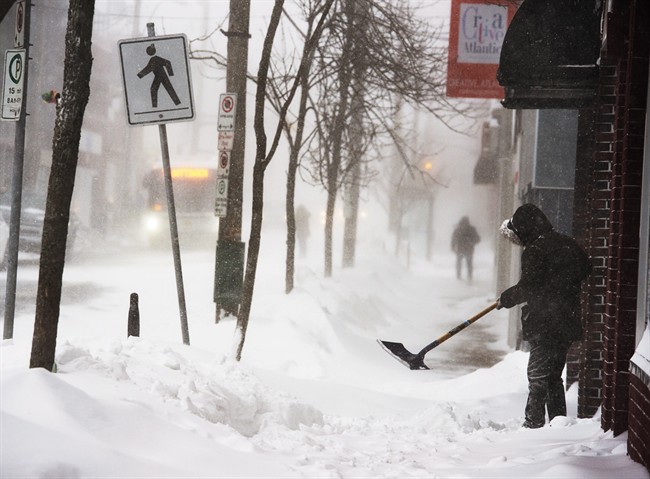 A man clears a sidewalk in blizzard conditions in Halifax on Friday, Jan. 3, 2014.