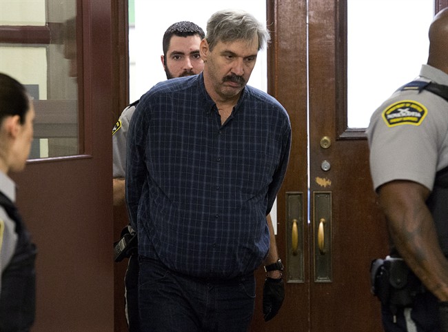 Michael Gerard Cooper is escorted at provincial court in Halifax on Jan. 28, 2014.