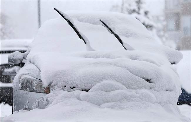 A car is covered in snow Sunday, Jan. 5, 2014, in Zionsville, Ind.