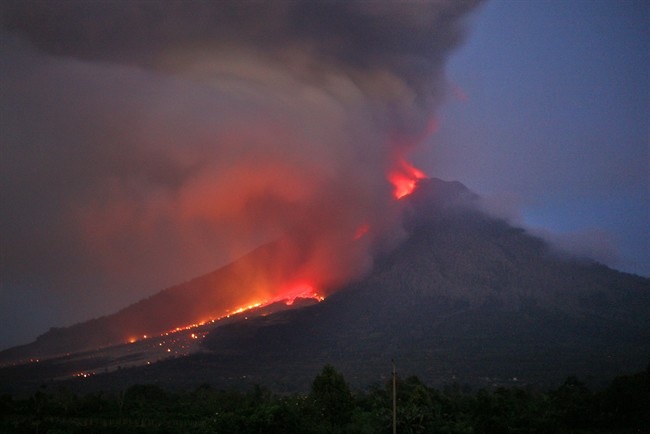 Mount Sinabung spews lava and volcanic ash as seen from Tiga Kicat, North Sumatra, Indonesia, early Tuesday, Jan. 7, 2014.