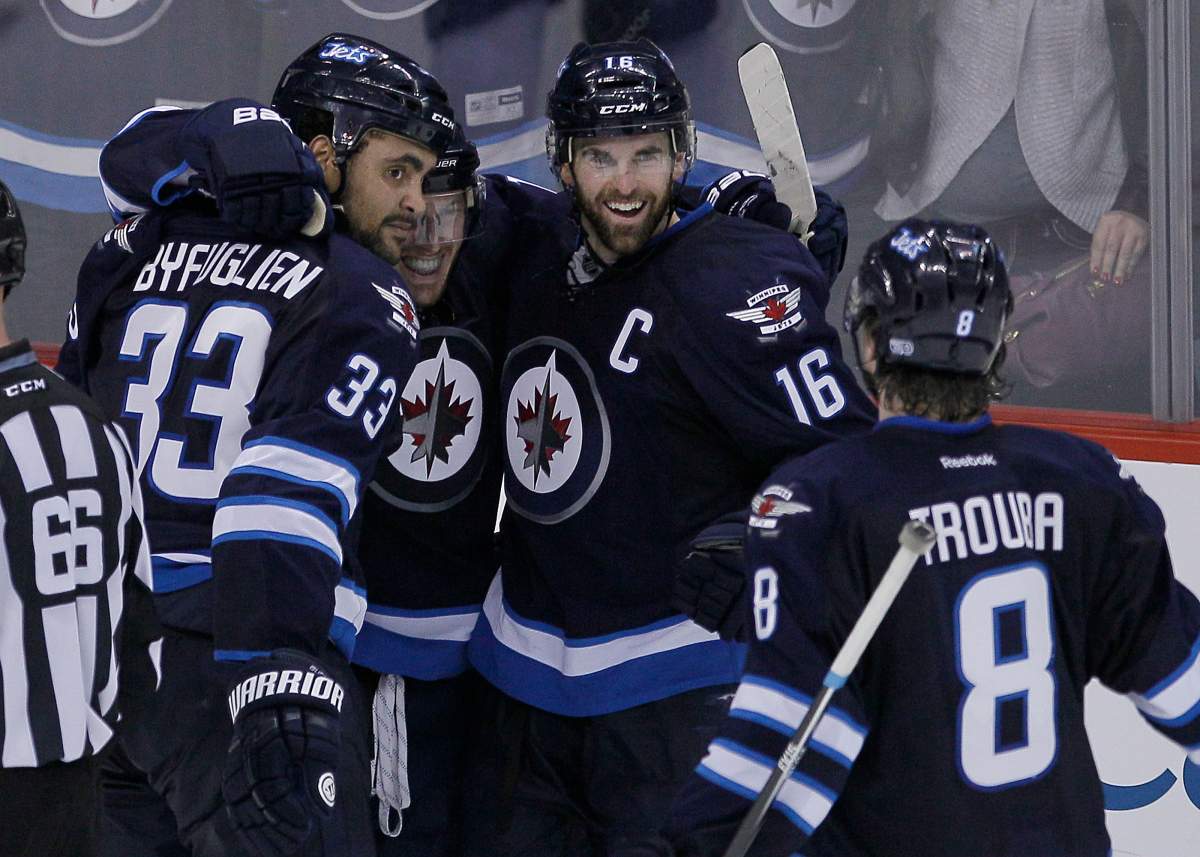 Winnipeg Jets' Dustin Byfuglien (33), Bryan Little (18), Andrew Ladd (16) and Jacob Trouba (8) celebrate Byfuglien's overtime goal to beat the Toronto Maple Leafs 5-4 in NHL action in Winnipeg on Saturday, January 25, 2014. 