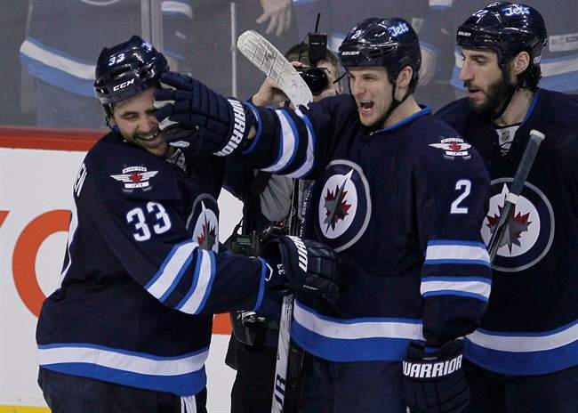 Winnipeg Jets' Dustin Byfuglien (33) and Adam Pardy (2) celebrate Byfuglien's overtime goal to beat the Toronto Maple Leafs 5-4 in Winnipeg on Saturday.