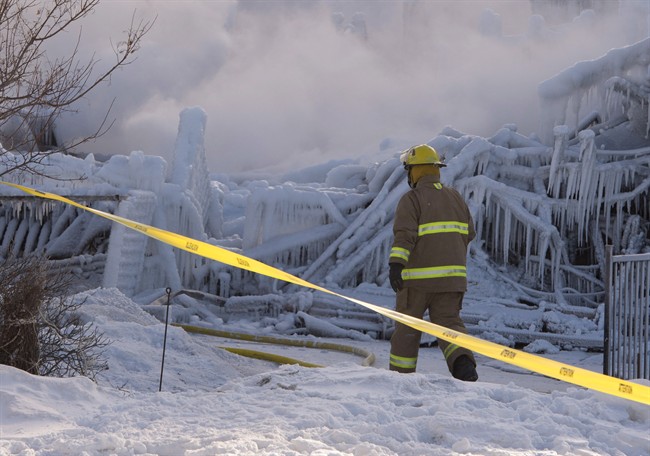 Firefighters work at the scene of a senior's residence fire on Thursday, January 23, 2014 in L'Isle-Verte, Que.