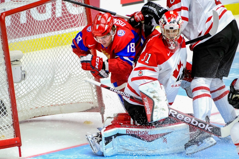 Russia's Vyacheslav Osnovin, left, is checked into the net behind Canada's goalie Zachary Fucale during the World Junior Hockey Championships bronze match between Canada and Russia at Malmo Arena in Malmo, Sweden, Sunday, Jan. 5, 2014. (AP Photo/Ludvig Thunman, TT News Agency).