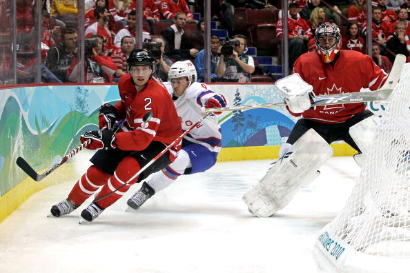 Duncan Keith of Canada controls the puck under pressure from Marius Holtet of Norway during the ice hockey men's preliminary game between Canada and Norway on day 5 of the Vancouver 2010 Winter Olympics at Canada Hockey Place on February 16, 2010 in Vancouver.