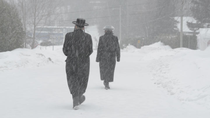 Members of Lev Tahor walk through their former community in Ste-Agathe-des-Monts, Quebec.