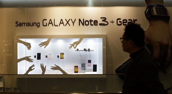 A man walks by a billboard for Samsung Electronics' Galaxy Note 3.