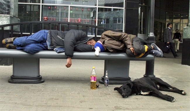 FILE - In this Sept. 2005 file photo, men sleep after drinking on a bench in downtown Moscow. Russian men who down large amounts of vodka _ and too many do _ have an “extraordinarily” high risk of an early death, a new study says.