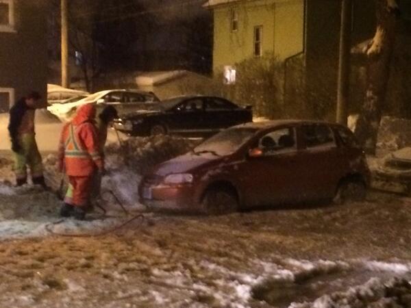 Crews work to free cars from frozen street after watermain break on South Osbourne and Maplewood Ave Monday night.