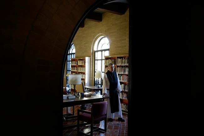In this Thursday, Jan. 9, 2014 photo Father Damion, Abbot at St. Joseph's Trappist Abbey in Spencer, Mass., stands in the community's library. 