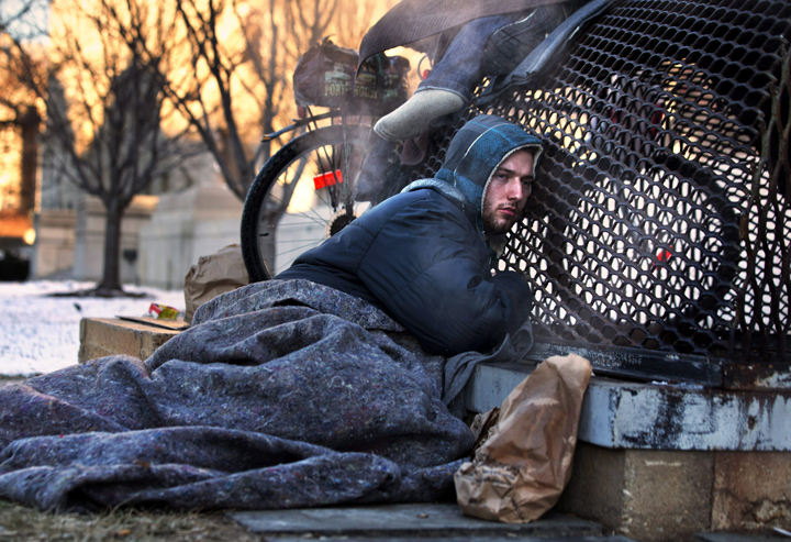 Nicholas Simmons, 20, of Greece, N.Y., warms himself on a steam grate with three homeless men by the Federal Trade Commission, just blocks from the Capitol, during frigid temperatures in Washington, Saturday, Jan. 4, 2014. His parents Paul and Michelle Simmons saw the photograph in USA Today Sunday morning after it was brought to their attention through a Facebook page set up to help find their son, according to police and family friends, and were able to report his location to D.C. police who transported him to a hospital where he was reunited with his father and brother who drove all day to find him. (Photo credit: AP Photo/Jacquelyn Martin). READ THE STORY HERE