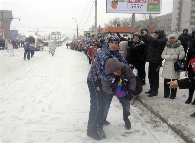 In this photo provided by Pavel Lebedev, security personnel detain Lebedev, a gay protester, during the Olympic torch relay in the city of Voronezh, 534 km (334 miles) south of Moscow, Saturday, Jan. 18, 2014. 