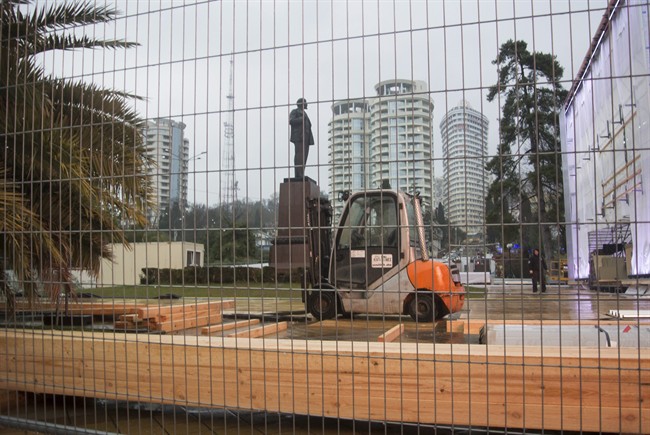 In this photo taken on Thursday, Jan. 23, 2014 a statue of Lenin stands in a central park in Sochi, Russia, surrounded by temporary fencing where workers are putting up one of the Olympic “live sites”. 