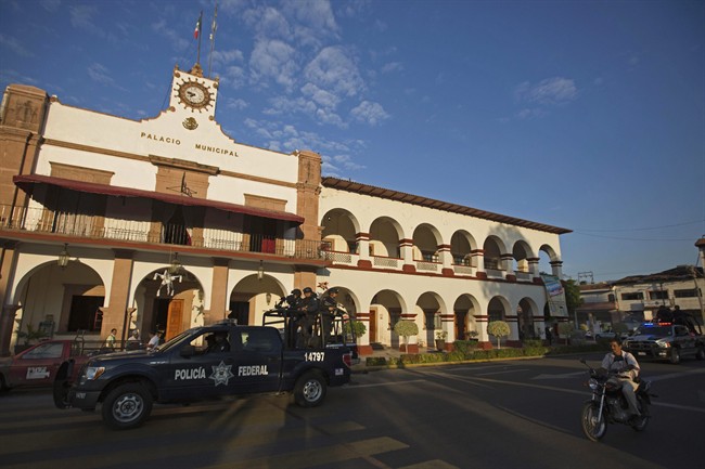 Federal police patrol outside City Hall in Apatzingan, Mexico, Wednesday, Jan. 15, 2014. 