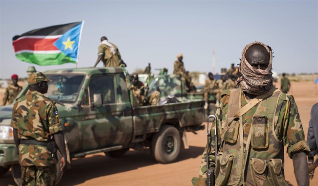 In this Sunday, Jan 12, 2014 file photo, South Sudanese government forces from the "Lion division" cheer their recent victory, after government forces on Friday retook from rebel forces the provincial capital of Bentiu, in Unity State, South Sudan.