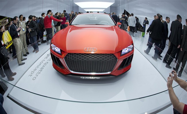 Trade show attendees gather around the Audi Sport quattro laserlight concept car at the International Consumer Electronics Show, Wednesday, Jan. 8, 2014, in Las Vegas. The car is outfitted with laser lights offering three times the illumination as LED lights. 