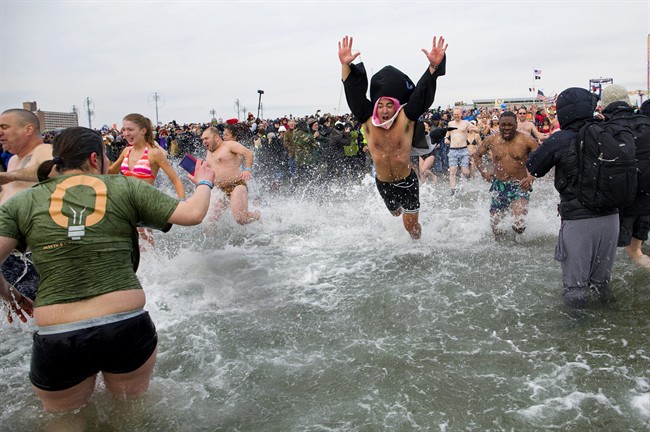 A first wave of swimmers jump into frigid waters at Coney Island beach in New York, Wednesday, Jan. 1 2014.