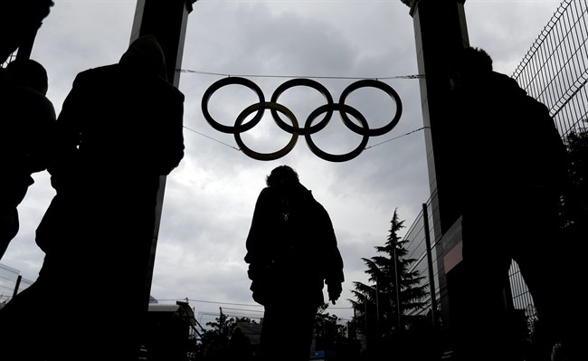 The Olympic rings hang above travelers leaving the central train station, Wednesday, Jan. 29, 2014, in Sochi, Russia, home of the upcoming 2014 Winter Olympics. (AP Photo/David Goldman).