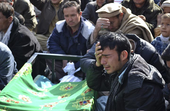 A Pakistani man, grieves next to the body of a relative, who was killed on Tuesday by a bomb blast, during a protest in Quetta, Pakistan, Wednesday, Jan. 22, 2014. 