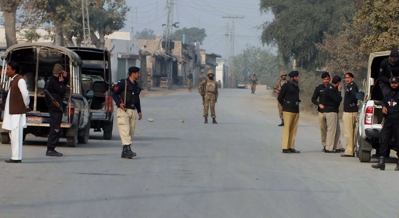 Pakistani police and army soldiers cordon off a road leading to the site of bomb explosion in Bannu, Pakistan on Sunday Jan. 19, 2014. (AP Photo/Ijaz Muhammad).