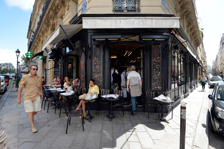 People sit at a cafe at a crossroad on the Ile Saint Louis island in central Paris on July 29, 2013.