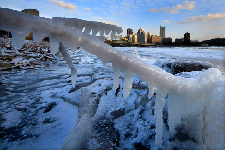 The skyline of Pittsburgh is framed by ice along the bank of the Allegheny river at sunset Tuesday, Jan. 7, 2014. 