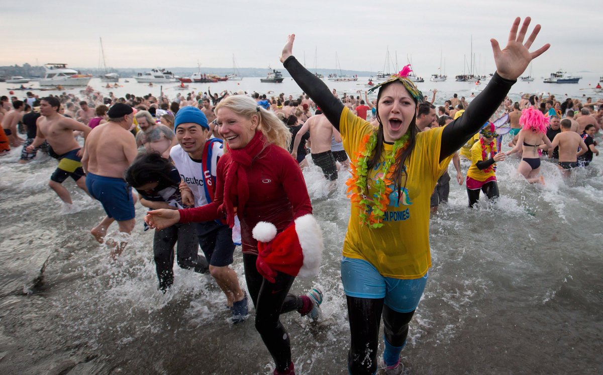 Participants take to the frigid waters of English Bay during the 93rd annual Polar Bear Swim in Vancouver, B.C., on Tuesday January 1, 2013. THE CANADIAN PRESS/Darryl Dyck.