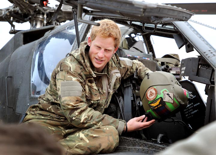 In this image released on January 21, 2013, Prince Harry, shows a television crew his flight helmet as he makes early morning checks as he sits on an Apache helicopter at the British controlled flight-line at Camp Bastion on December 12, 2012 in Afghanistan. 