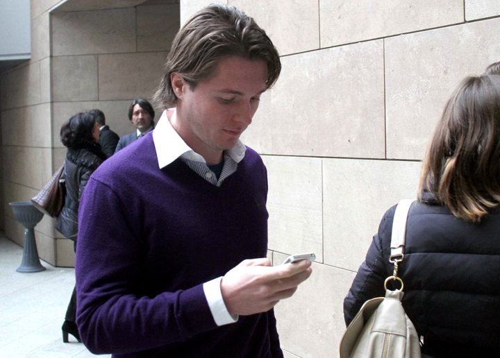 Raffaele Sollecito checks his smart phone as he enters the Florence court, Italy, Thursday, Jan. 9, 2013.