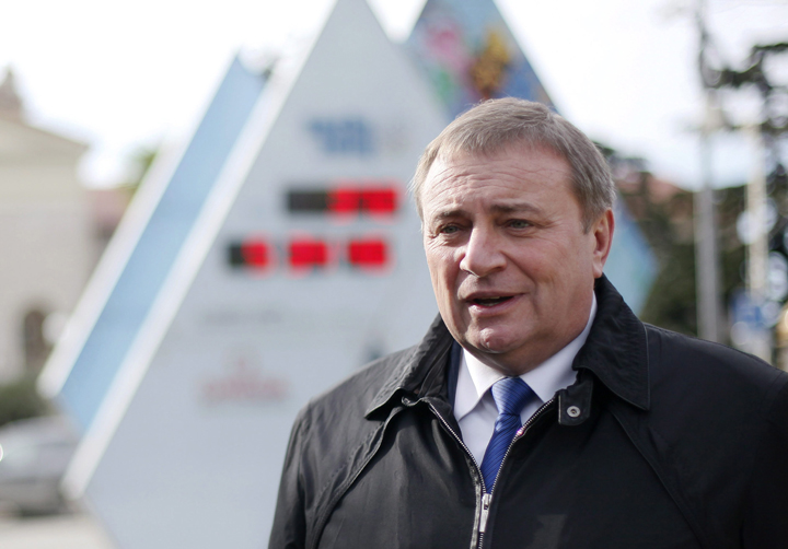 In this Thursday, Jan. 31, 2013 photo Sochi's Mayor Anatoly Pakhomov poses with count-down clock in Sochi. 