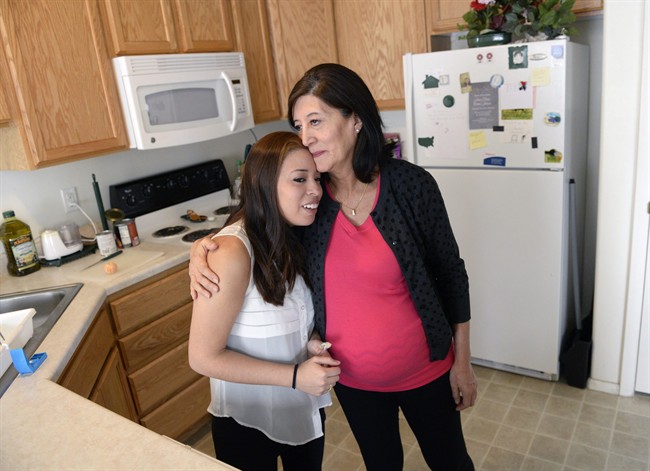 In an undated photo Julia Navarro, 58, right, hugs her daughter Lorena McKinnon in Provo, Utah. McKinnon has never been able to bring a baby to term so her 58-year-old mother is having the baby for her. 
