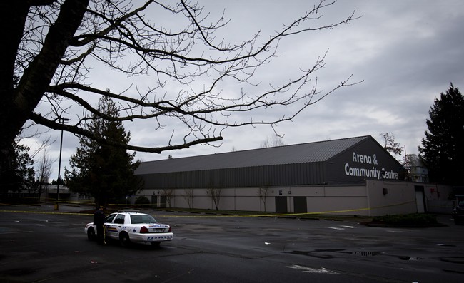 RCMP officers talk outside the Newton Arena in Surrey, B.C., on Monday December 30, 2013, where a 53-year old woman was killed.