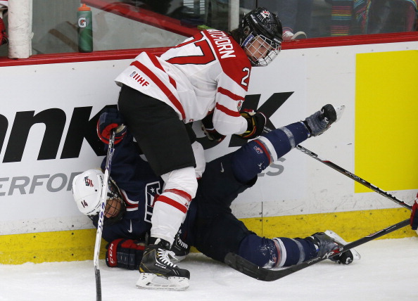 Team Canada's Tara Watchorn #27 hits Team USA's Brianna Decker against the boards during the first period of their National Women's Team Series December 12, 2013 in Calgary.