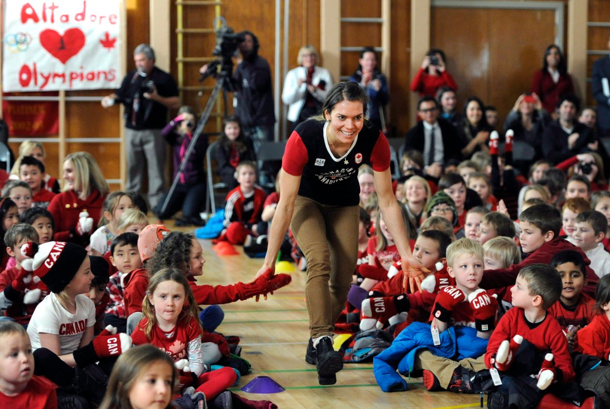 Heidi Widmer of Banff, Alta., greets schoolchildren as she is named to the Canadian Olympic cross country team during a press conference at a school in Calgary, Alberta on Tuesday, January 14, 2014. 