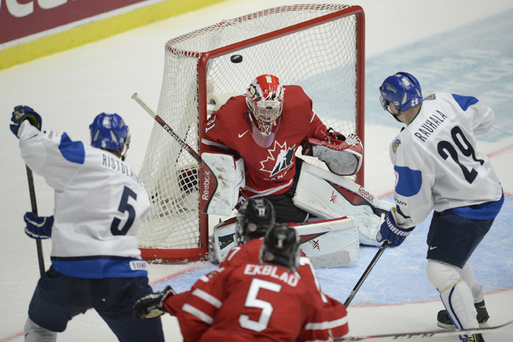 Finland's Rasmus Lehtonen (left) scores on Canada's Zachary Fucale as Finland's Otto Rauhala (right) and Canada's Aaron Ekblad (bottom) look on during second period semi-final IIHF World Junior Hockey Championship action in Malmo, Sweden on Saturday, January 4, 2014.