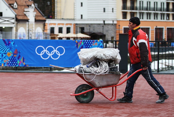 A worker carries supplies to a construction site in the Rosa Khutor Mountain Cluster village ahead of the Sochi 2014 Winter Olympics on January 31, 2014 in Sochi, Russia.  