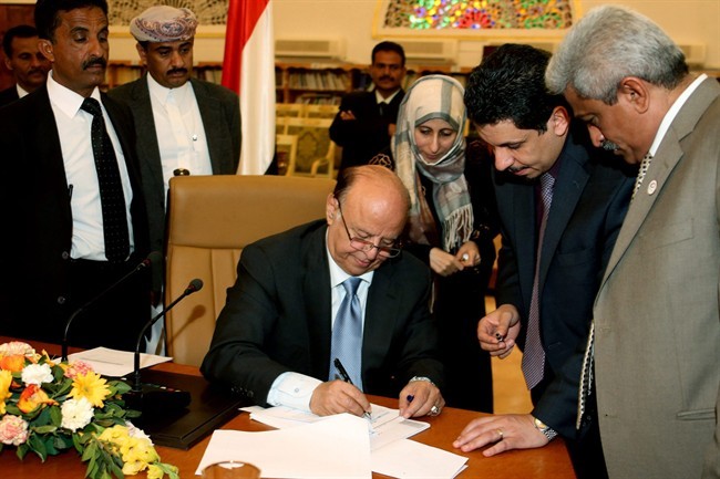In this photo provided by Yemen's Defense Ministry, Yemeni President Abed Rabbo Mansour Hadi signs the final approval on transforming Yemen into a federal state of six regions in Sanaa Yemen, Monday, Feb. 10, 2014. A key Yemeni panel tasked with devising a new system to address the local grievances that have fed the impoverished Arabian Peninsula nation's instability agreed Monday to transform the country into a state of six regions.