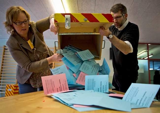 Electoral workers empty a ballot box at a makeshift polling station after Swiss voters went to the polls to decide on a proposal to cap immigration to the Alpine republic, in the center of Geneva, Switzerland, Sunday, Feb. 9, 2014. The nationalist Swiss People’s Party demands a stop for immigration to Switzerland. 