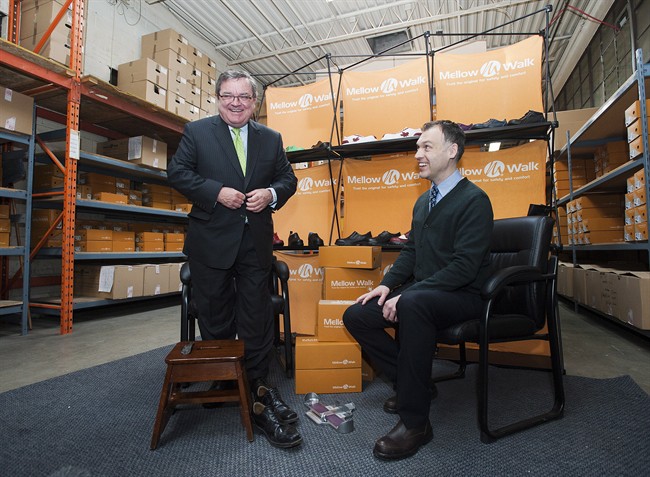 Finance Minister Jim Flaherty tries on a pair of shoes with Andrew Violi president of Mello Walk Shoes at a pre-budget press event in Toronto on Friday February 7, 2014. THE CANADIAN PRESS/Aaron Vincent Elkaim.