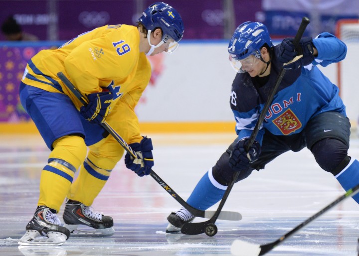 Sweden's Nicklas Backstrom (L) vies with Finland's Jussi Jokinen during the Men's Ice Hockey Semifinal match between Sweden and Finland at the Bolshoy Ice Dome during the Sochi Winter Olympics on February 21, 2014. AFP PHOTO / YURI KADOBNOV .