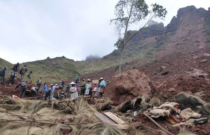 Farmers dig through the mud in search of survivors and recovery of bodies after a mudslide buried a small settlement in Chullpa Kasa, Bolivia, Sunday, Feb. 9, 2014. 