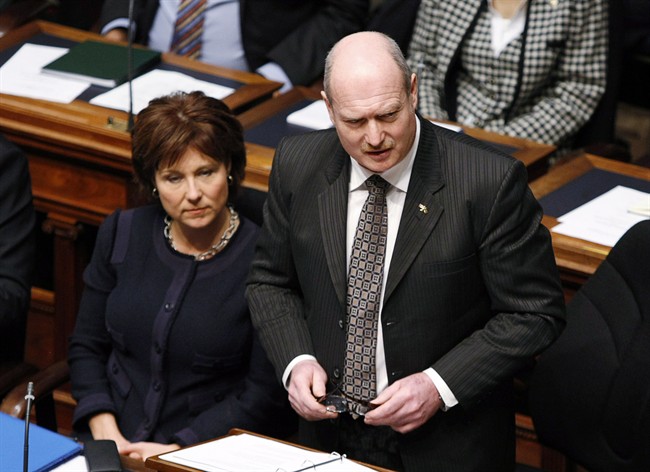 Premier Christy Clark (left) listens as B.C. Finance Minister Mike de Jong tables the provincial budget in the Legislative Assembly Tuesday, February 18, 2014 in Victoria, B.C. THE CANADIAN PRESS/Chad Hipolito.