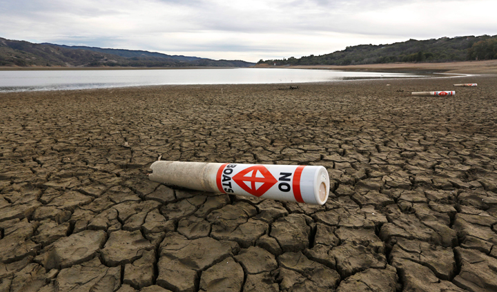 In this Feb. 4, 2014 file photo a warning buoy sits on the dry, cracked bed of Lake Mendocino near Ukiah, Calif.