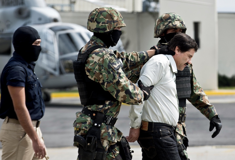 Mexican drug trafficker Joaquin Guzman Loera aka 'el Chapo Guzman', is escorted by marines as he is presented to the press on February 22, 2014 in Mexico City. AFP PHOTO/RONALDO SCHEMIDT.