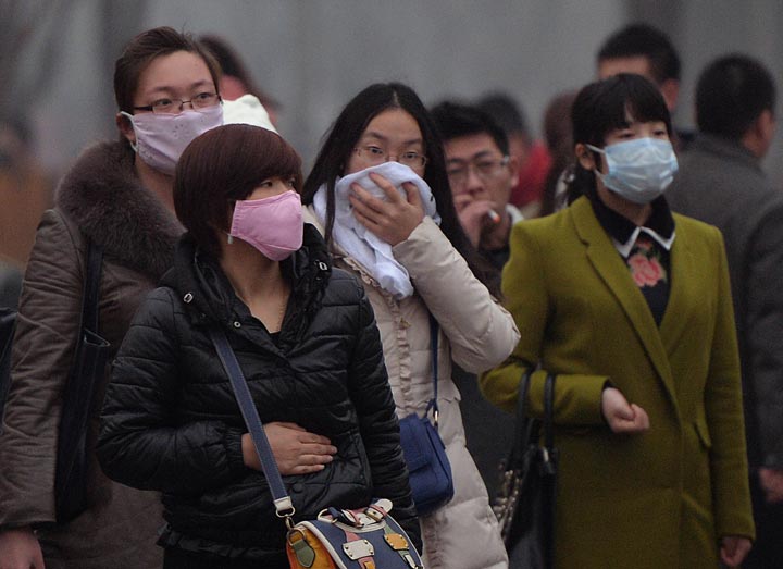 Chinese commuters wear face masks as heavy air pollution continues to shroud Beijing on February 25, 2014. (Mark Ralston/AFP/Getty Images)