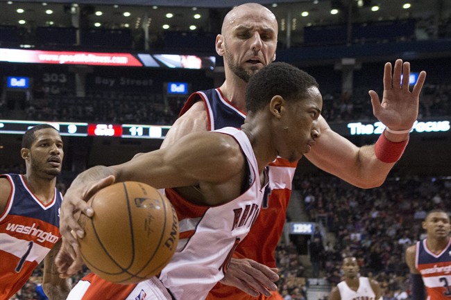 Toronto Raptors' DeMar DeRozan drives past Washington Wizard's Marcin Gortat during first half NBA basketball action in Toronto, Thursday, Feb. 27, 2014.