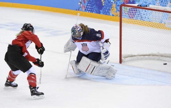 Canada’s Meghan Agosta-Marciano (L) scores a goal past US goalkeeper Jessie Vetter during the Women’s Ice Hockey Group A match between Canada and USA at the Sochi Winter Olympics on February 12, 2014 at the Shayba Arena.