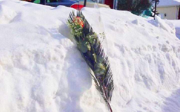 Flowers left outside the home where the bodies of three young people were discovered on February 11, 2014.
