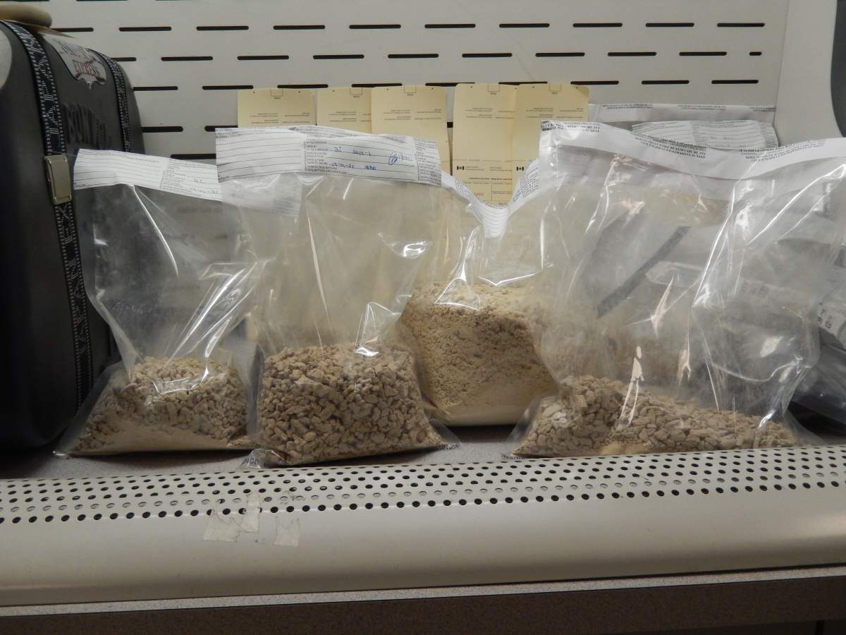 Seized suspected heroin and false-bottom suitcases used to conceal the narcotics.