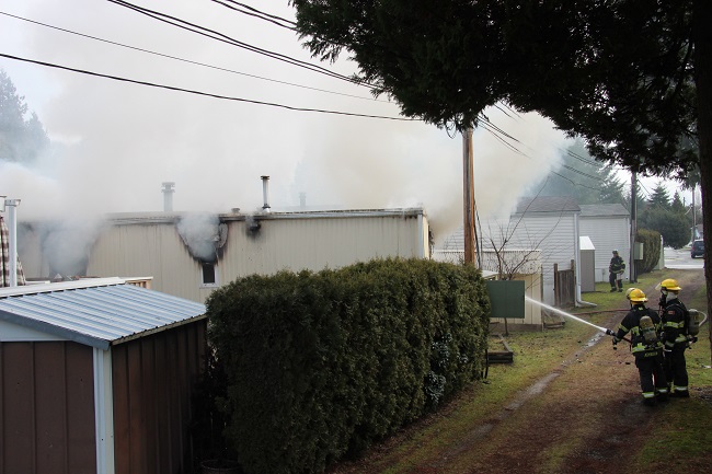 Fire crews battle a blaze at a Langley mobile home park Friday morning. 